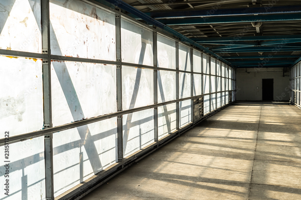 Modern overhead passage from steel and glass, perspective, long tunnel in sunset light Modern overhead passage from steel and glass, perspective, long tunnel in sunset light