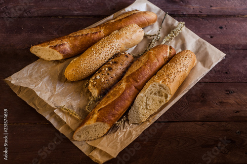mix of sorts of baguettes on a wooden table. Bakery products.