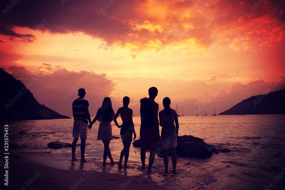 Friends on beach at sunset