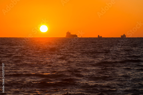 日の出の太陽と水平線と渡る船たち © Kouzi.Uozumi