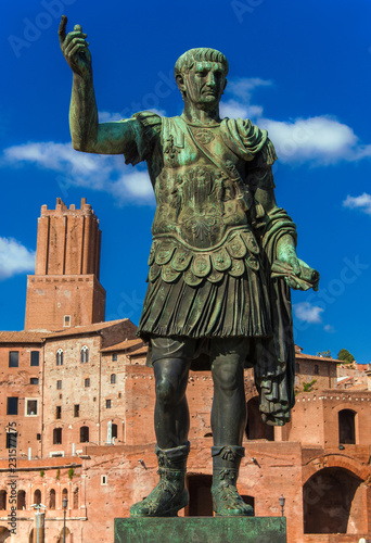 Caesar Augustus Trajan  emperor of Ancient Rome. Bronze statue with Imperial Fora ruins and Tower of Militia and ruins in the background