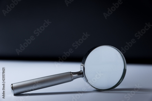 silver magnifying glass on black and white background, nice effect