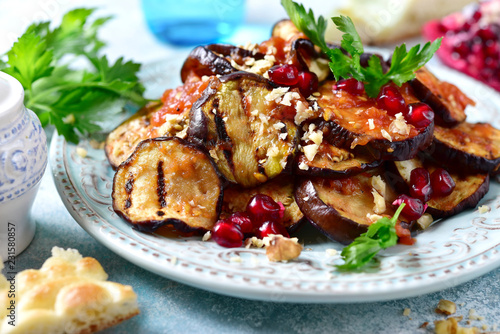 Grilled eggplants in tomato sauce with walnuts and pomegranate seeds.
