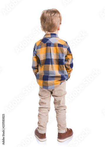 Rear view of little boy with hands in his pockets, isolated on white background