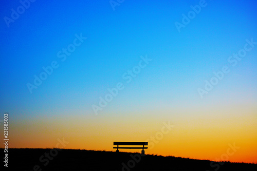夕暮れの丘のベンチ