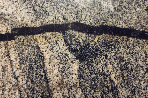 Abstract granite texture with solid black snake-like seam photo