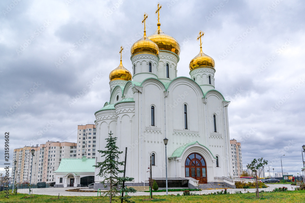 Eastern orthodox crosses on gold domes, cupolas, againts blue sky with clouds.