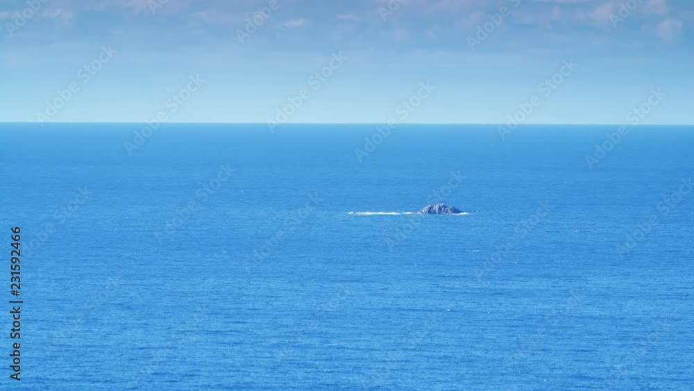 Greek blue calm sea water surface with little rocky island and skyline, Greece Peloponnese Mani Peninsula Greek blue calm sea water surface with little rocky island and skyline, Greece Peloponnese Mani Peninsula