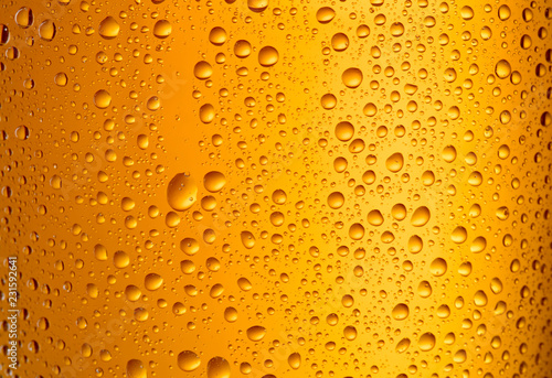 fresh cool beer in glass with droplets as textured background