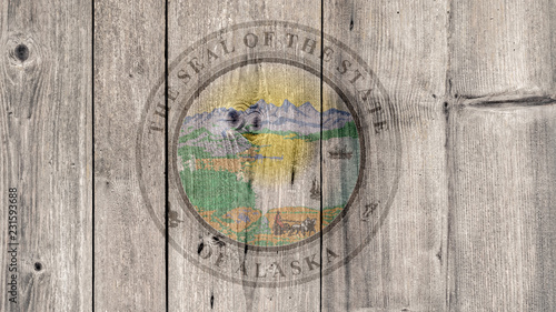 USA Politics News Concept: US State Alaska Seal Wooden Fence Background