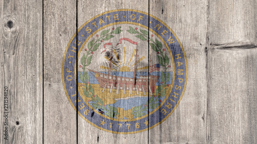 USA Politics News Concept: US State New Hampshire Seal Wooden Fence Background