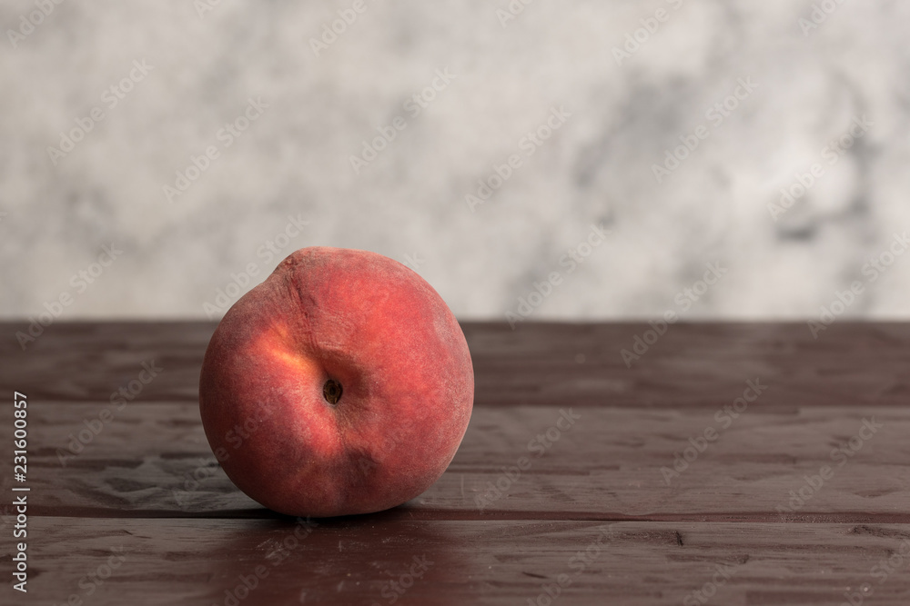 Ripe peach fruit isolated on rustic wooden surface with clear marble background Ripe peach fruit isolated on rustic wooden surface with clear marble background