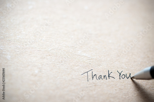 Hand writing thank you on piece of old grunge paper photo
