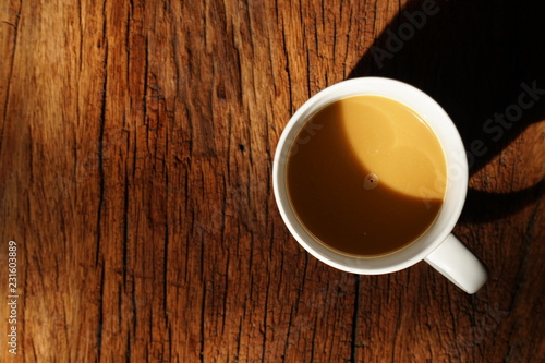 Hot coffee on wooden table, The best instant coffee served with banana cake. Porcelain coffee cup on table with dessert, Selective focus and free space for text. Industrial food and drink concept.