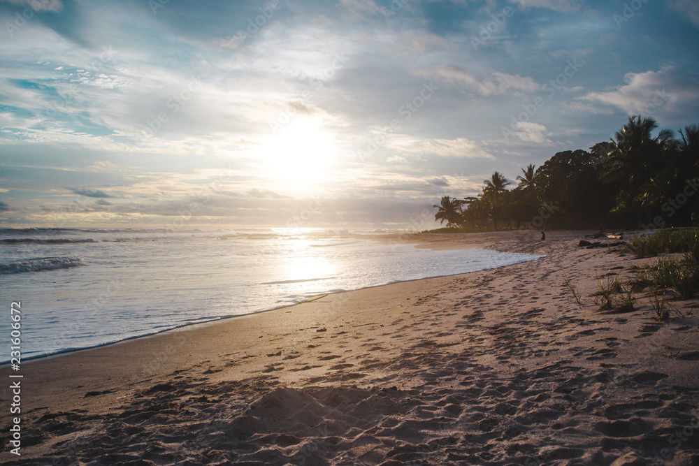 Waves lap at the beach during sunset in Santa Teresa, Costa Rica