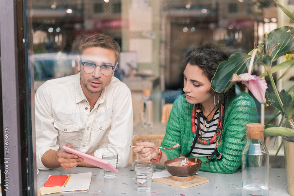 Family business. Cute couple having breakfast in cafeteria thinking about launching family business Family business. Cute couple having breakfast in cafeteria thinking about launching family business