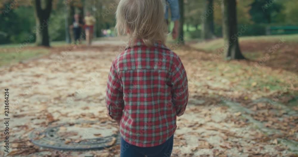 Little toddler walking in the park with his mother in autumn Little toddler walking in the park with his mother in autumn