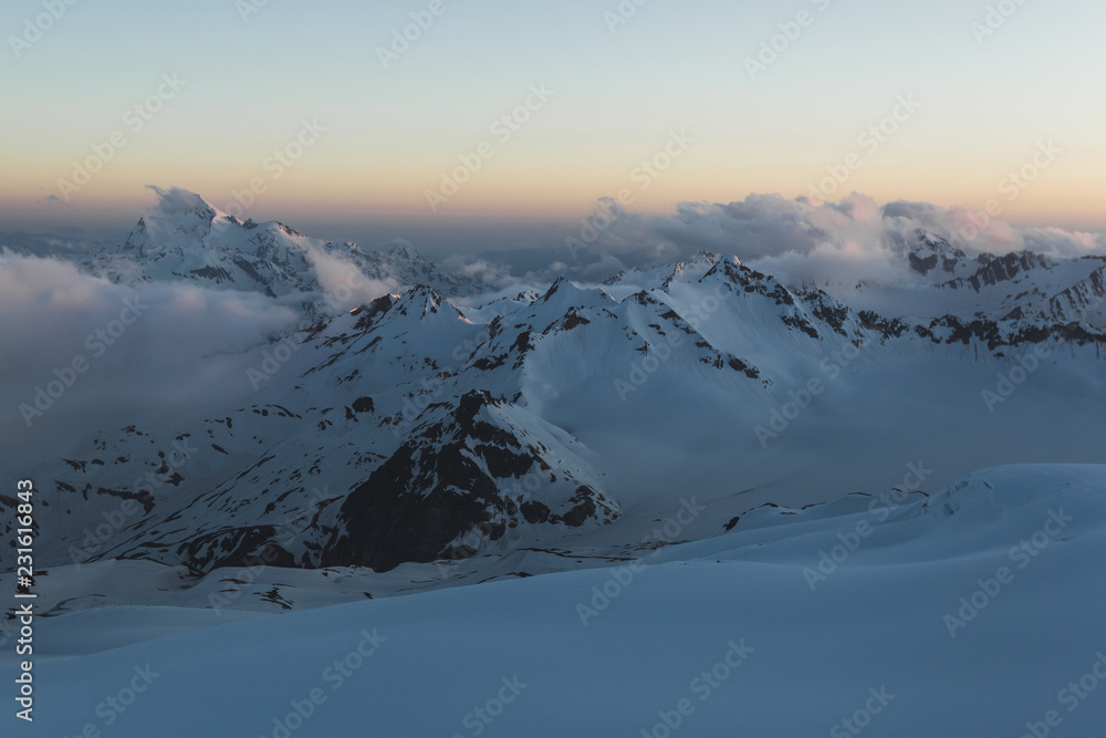 Panoramic view of high mountain peaks in twilight. Hiking and climbing in Elbrus region
