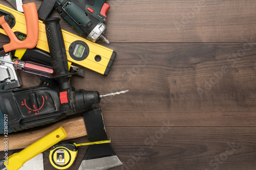 different construction tools on wooden background with copy space. diy construction tools on the brown table