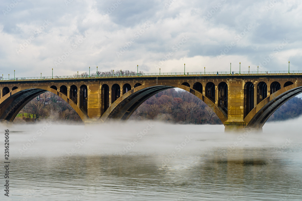 Fototapeta premium Francis Scott Key Bridge across Potomac River, winter fog on the water.
