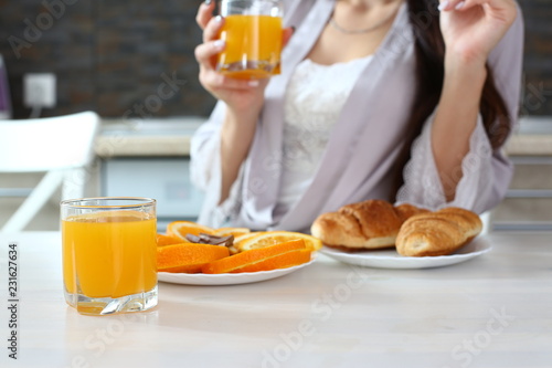 beautiful woman in the kitchen eating a juice