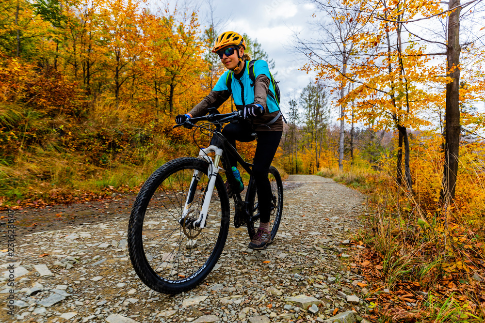 Mountain biking woman riding on bike in summer mountains forest landscape. Woman cycling MTB flow trail track. Outdoor sport activity.