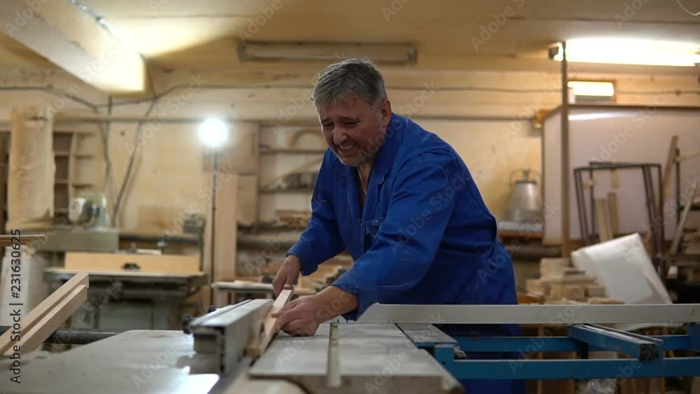 Carpenter at work at his workshop, wood processing on a woodworking machine Carpenter at work at his workshop, wood processing on a woodworking machine
