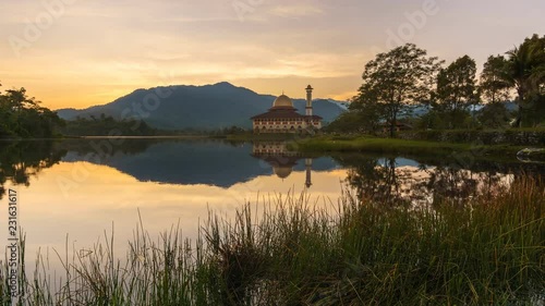 Beautiful sunrise with reflection of sunrise and the Darul Quran Mosque photo