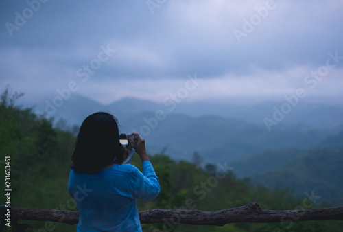 Asian woman take a photo at mountain natural view point with fog in morning.freedom lifestyle travel concept.