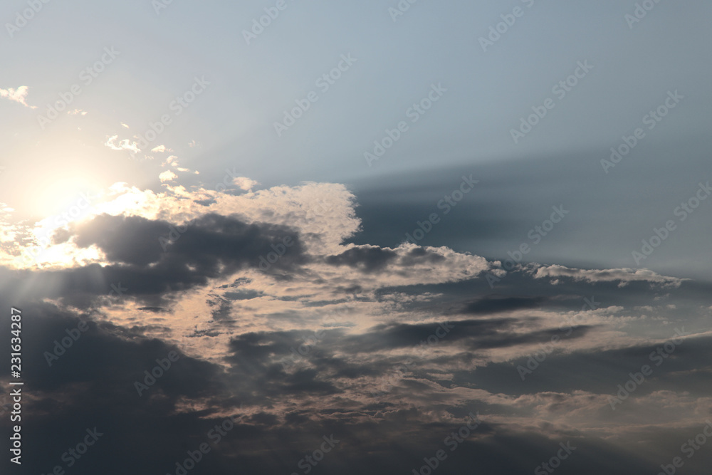The image of clouds in the blue sky. The sun shines through the clouds. Background. Cropped shot, close-up, nobody
