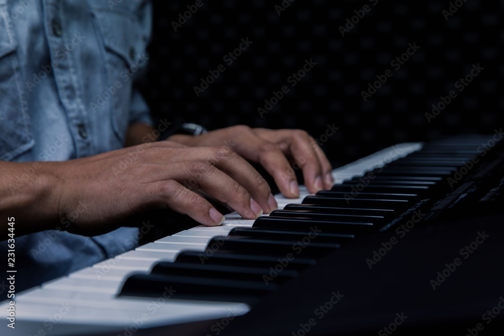 Fototapeta premium Close-up of a music performer's hand playing the piano