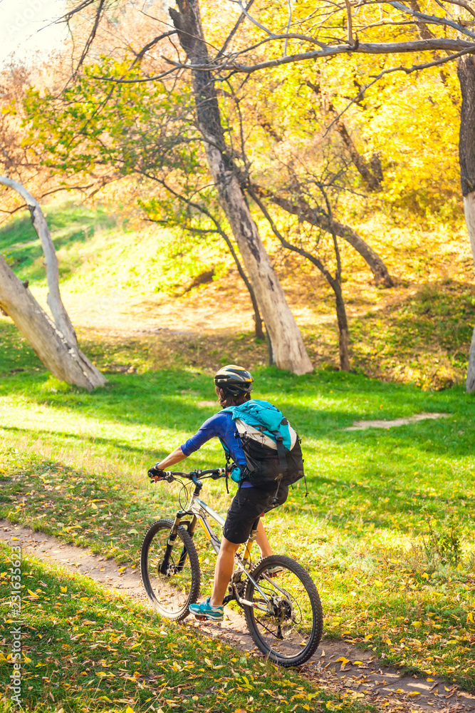 The girl rides a bike in the autumn park. The girl rides a bike in the autumn park.