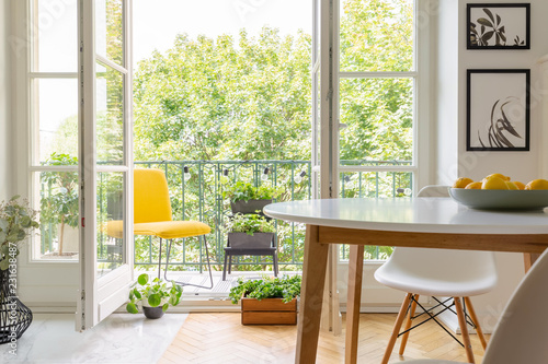 Carta da parati Yellow chair on the balcony of elegant kitchen interior with white wooden chair