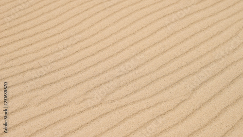 Diagonal waves of sand. Sandy texture background.