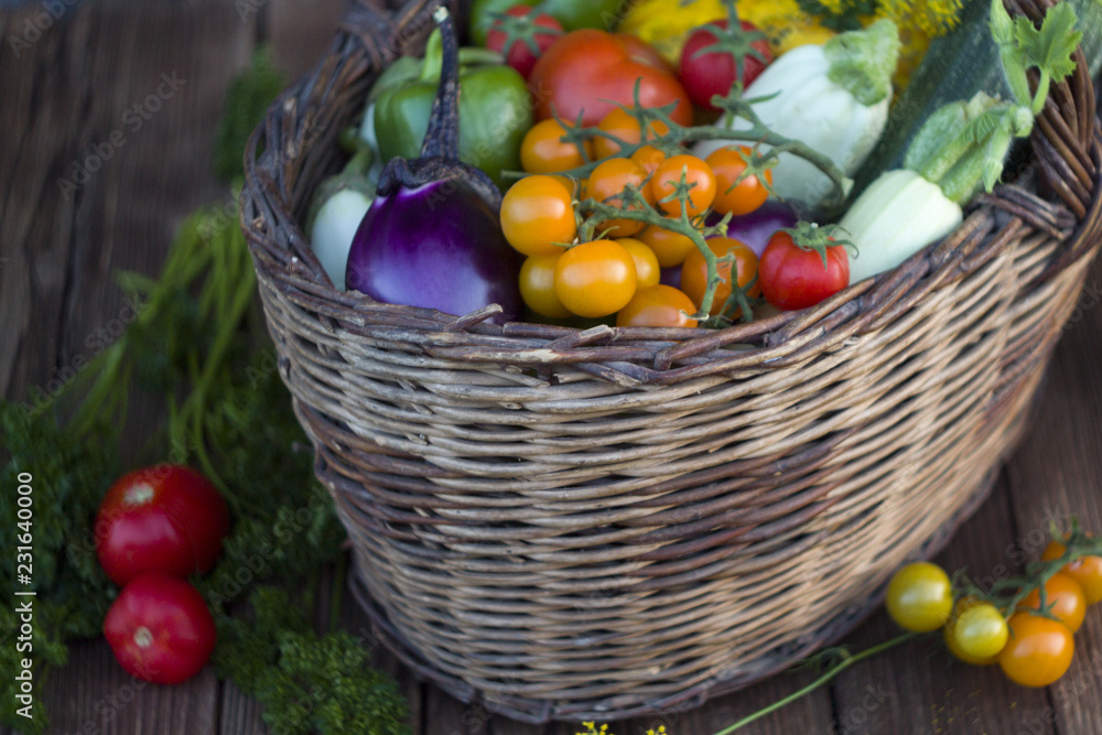 Fresh vegetables in a basket on a rustic wooden table with space for text. Fresh vegetables in a basket on a rustic wooden table with space for text.
