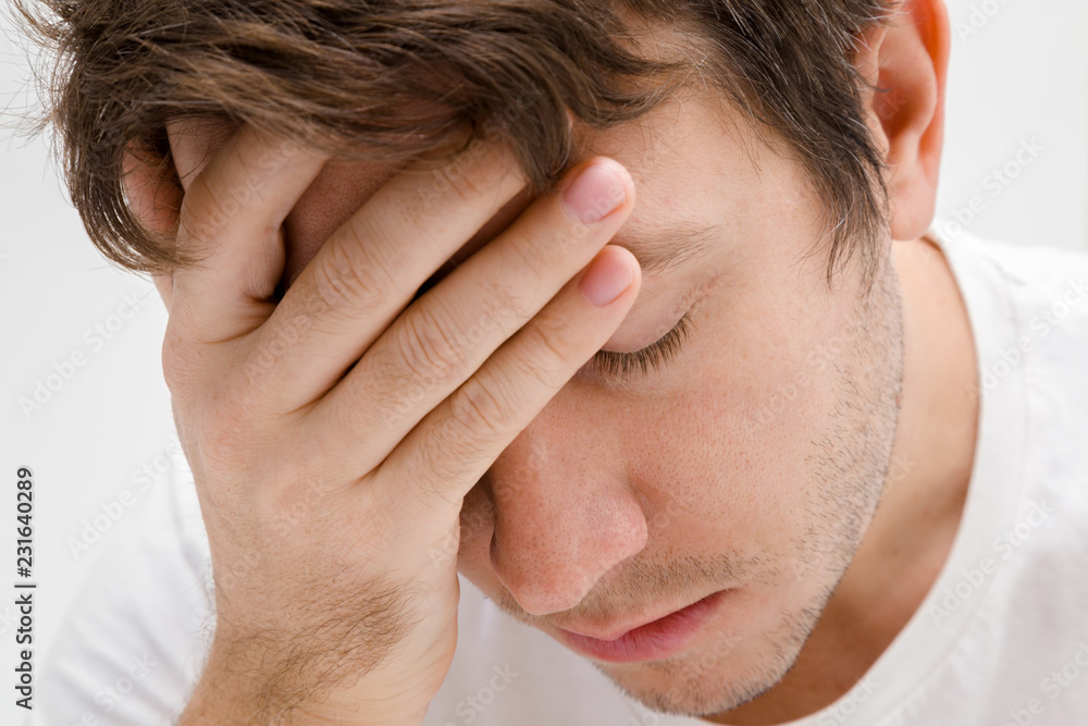 Young lonely, grieving man touching head. Suffering from heartbreak, burnout or other psychological problems. Memory disorder. Men's issues. Face close up. Adult brunette guy. Young lonely, grieving man touching head. Suffering from heartbreak, burnout or other psychological problems. Memory disorder. Men's issues. Face close up. Adult brunette guy.