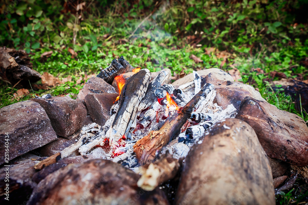 burning firewood on small campire surrounded by stones burning firewood on small campire surrounded by stones