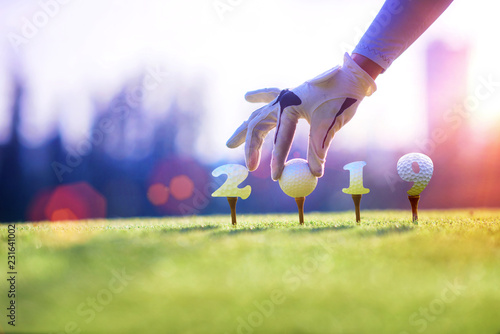 concept of golf ball invitation on incoming year 2019, prepare by hand of woman on tee off,  ready to hit away the new year success on fairway, Happy new year and merry christmas on golf course