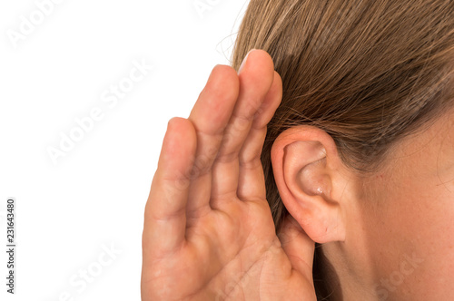 Woman is listening with her hand on an ear