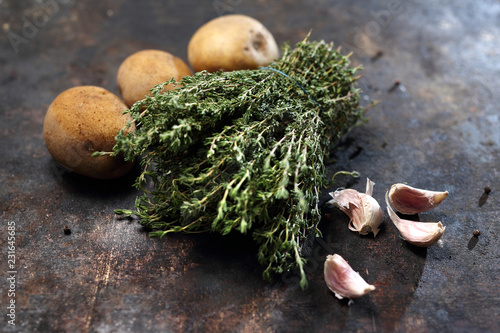 Ziemniaki z czosnkiem i tymiankiem. Składniki potraw, ekologiczne ziemniaki ze świeżymi ziołami tymianku.