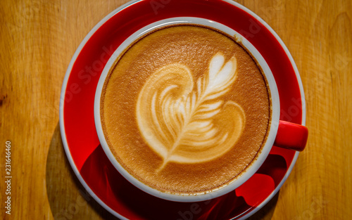 red cup of hot latte coffee with latte art