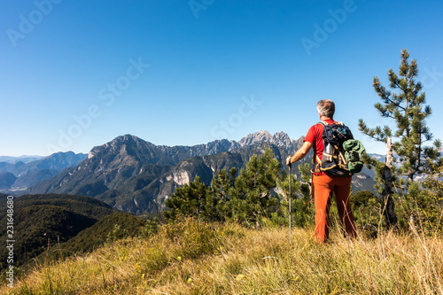 Man hiker is admiring the range mountains landscape.