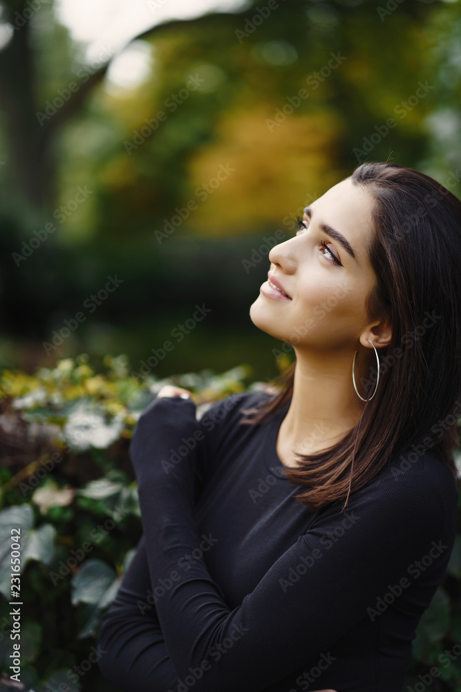 brunette girl walking through the park during autumn brunette girl walking through the park during autumn