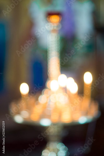 blured believer puts a candle on the candlestick in the church