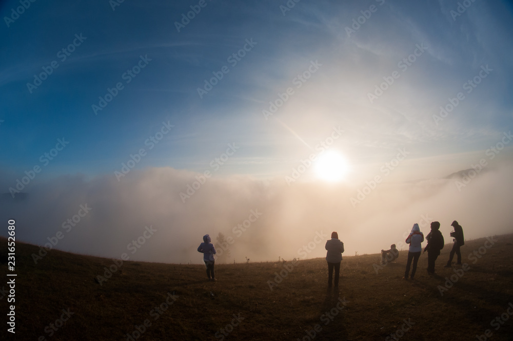 People silhouettes on top of mountain at sunrise
