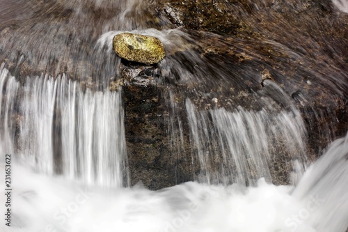 Stone lies in front of a small waterfall in current, mountain stream, symbolism, steadfastness, all against one, against the stream, Val Genova, Genova valley, near Carisolo, Adamello-Brenta nature park Park, Vinschgau, Trentino-South Tyrol, Italy, Europe