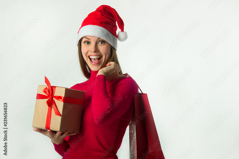 beautiful young girl in santa claus hat with a gift in her hands on a white background beautiful young girl in santa claus hat with a gift in her hands on a white background