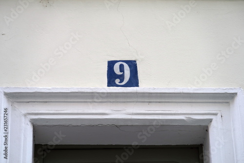 Numéro 9 sur façade blanche