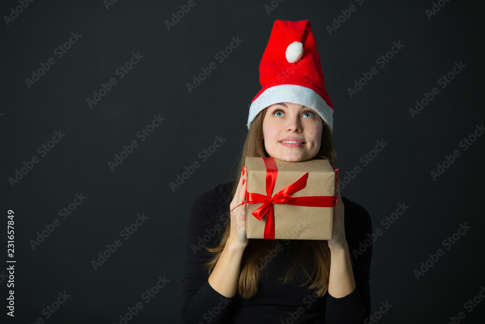 beautiful young girl with a gift in hand on a black background