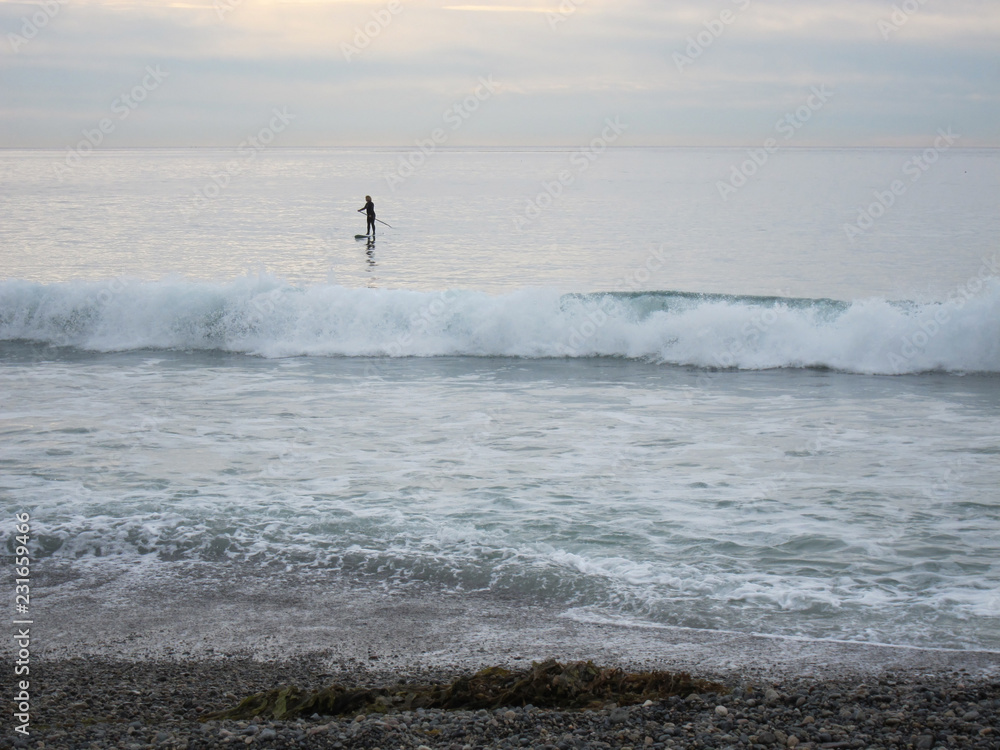 Lone paddleboarder on the beach Lone paddleboarder on the beach